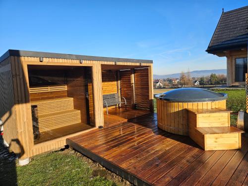 una gran terraza de madera con bañera de hidromasaje. en beskid.house1, en Spytkowice