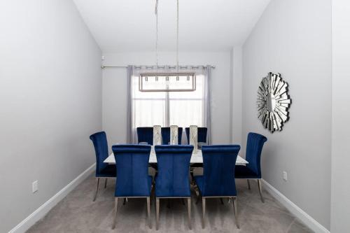 Un comedor con una mesa y sillas azules. en Silver Lining - Luxury for 10, en Haines City