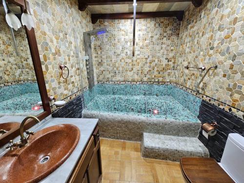 a bathroom with a tub and a sink at Alojamientos Rurales Benarum con Spa in Alpujarra De La Sierra