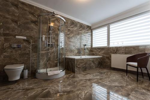 a bathroom with a shower and a toilet and a sink at Hotel Europejski in Nysa