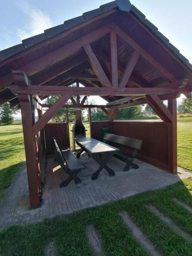 a wooden pavilion with a picnic table and a bench at Apartmán KaTry in Veľká Lomnica