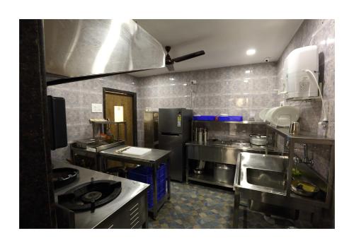 a large kitchen with stainless steel appliances andphalt at Hotel Kochi Caprice in Cochin