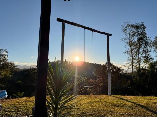 a swing with the sunset in the background at CABANAS BELVEDERE- SERRA DO RIO Do RASTRO in Louro Müller
