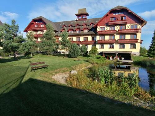 a large building with a pond in front of it at Apartmán KaTry in Veľká Lomnica