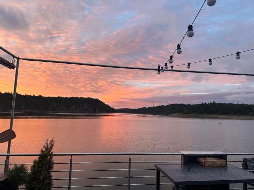 a view of a lake from a deck at sunset at Luxury houseboat, Orlík Castle in Orlík