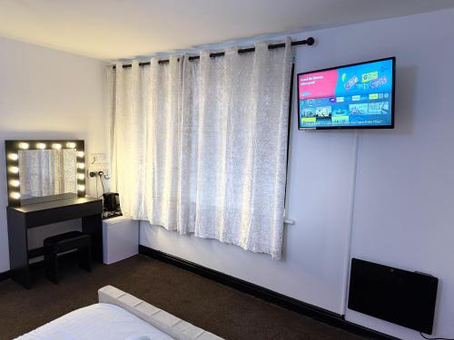 a room with a television on a wall with a bed at Mansa Halifax in Halifax