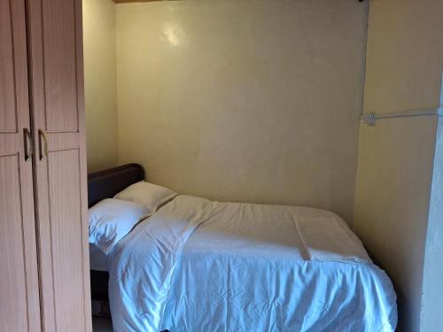a small bedroom with a bed and a closet at MALI bnb in Ruaka