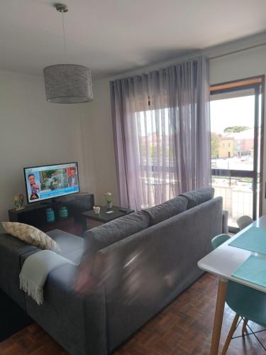 a living room with a couch and a television at Apartamento Solzende in Esposende