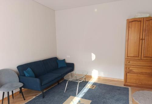 a living room with a blue couch and a cabinet at Sweet Home Mergelyan in Yerevan