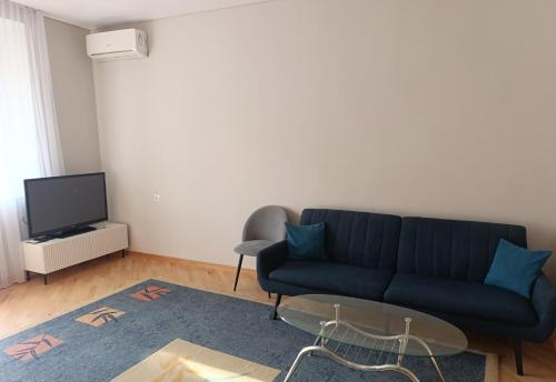 a living room with a blue couch and a tv at Sweet Home Mergelyan in Yerevan