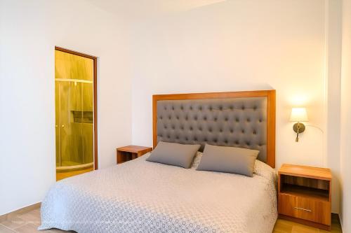 a bedroom with a large bed with two pillows at Suites C O V A D O N G A in Mexico City