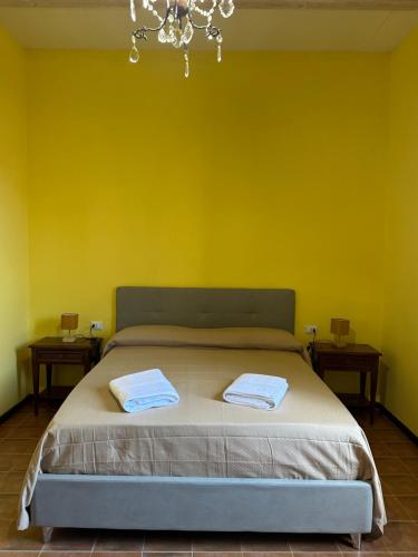 a bedroom with a bed with a yellow wall at Dimora Borgo Torre in Rutino