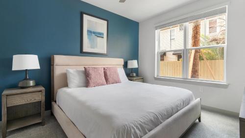 une chambre bleue avec un lit et une fenêtre dans l'établissement Historic Springfield Apartments by Landing, à Jacksonville