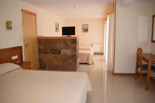 a bedroom with a bed and a television on a wall at Hotel VIDA Playa Paxariñas in Portonovo