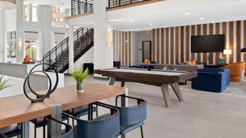 a living room with a ping pong table and chairs at Landing Incredible 1BD Pool Gym in Orlando
