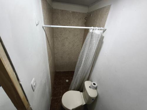 a small bathroom with a toilet and a shower at Cabaña Gaia Rodadero in Santa Marta