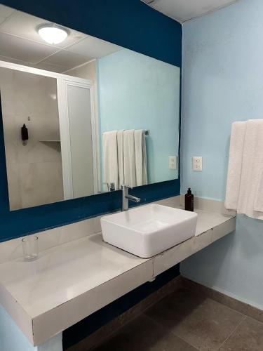 łazienka z białą umywalką i lustrem w obiekcie Acamar Beach Resort w Acapulco