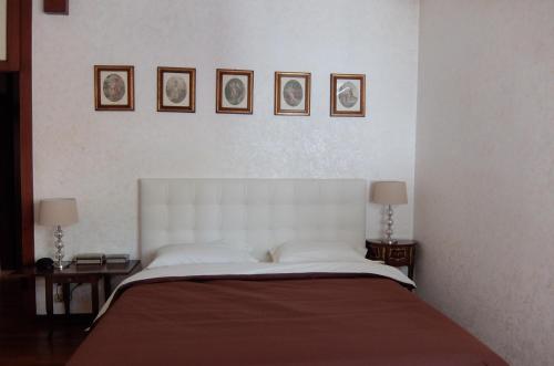 a bedroom with a large bed with three pictures on the wall at La Casa di Enrico in Caorle