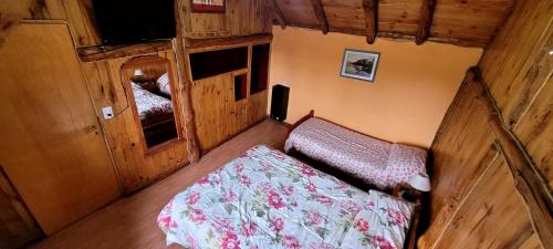 a small bedroom with a bed in a cabin at Cabañas Clarita in Dina Huapi