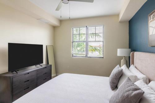 a bedroom with a bed and a flat screen tv at Landing at Mosaic at Miramar - Miramar in Miramar