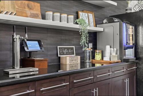 a kitchen with a counter top with a coffee shop at Landing at Mosaic at Miramar - Miramar in Miramar