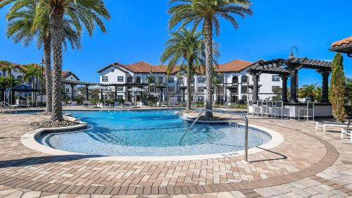 a swimming pool with palm trees in a resort at Landing at Marisol at Viera - Melbourne in Viera