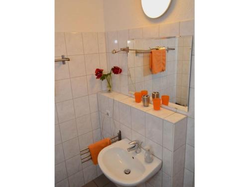 Un baño blanco con lavabo y espejo. en Holiday apartment "Opera", en Leipzig
