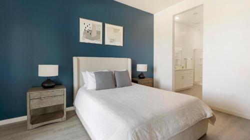 a bedroom with a large bed and a blue wall at Landing at Linda Vista - Oro Valley in Oro Valley
