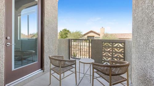 a patio with two chairs and a table on a balcony at Landing at Linda Vista - Oro Valley in Oro Valley