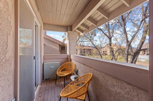 a balcony with two chairs and a window at Hikers Hideaway - Cozy Resort Condo with Pool & More in St. George