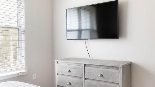 a tv on top of a dresser in a bedroom at Landing Apartments Dry Creek - Huntsville in Huntsville