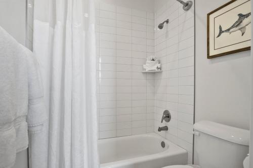 a bathroom with a white shower curtain and a toilet at By the Sea - Ocean Vibes in the Desert in Washington