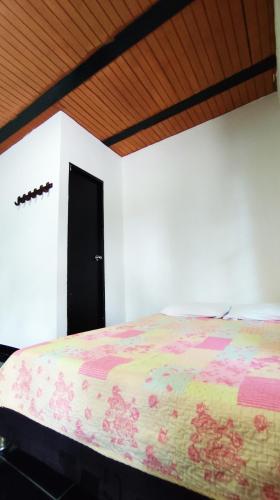 a bedroom with a large bed with a black door at Finca la Campechana in Cumaral