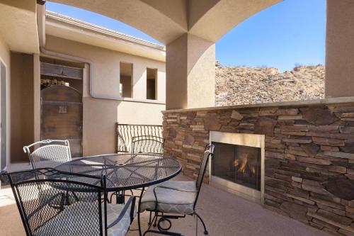 a patio with a table and chairs and a fireplace at Utahs Beauty with Desert & Mtn Views in Washington