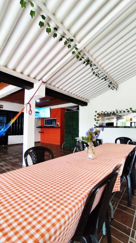 a dining room with a red and white checkered table and chairs at Finca la Campechana in Cumaral