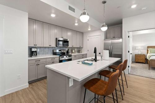 a kitchen with a large white counter and chairs at Cliffside Vista - Stay for 7 in Hurricane