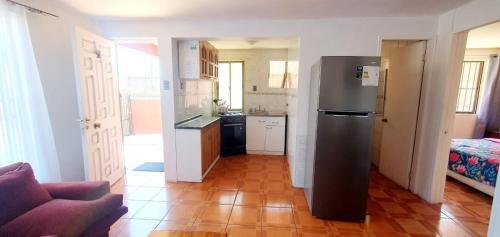 a kitchen with a stainless steel refrigerator in a room at Cabañas Jardín Alto in Pichilemu