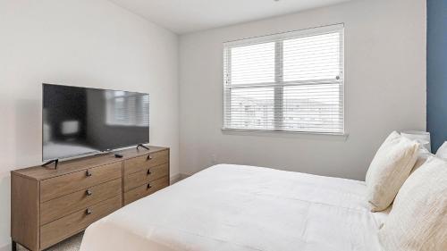 a bedroom with a bed and a flat screen tv at Landing at Jameson - Rockwall in Rockwall