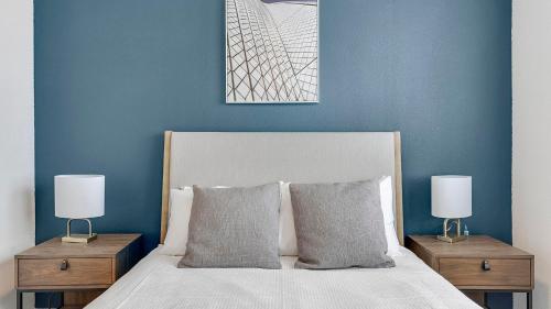 a blue bedroom with a bed with two nightstands and two lamps at Landing at Jameson - Rockwall in Rockwall
