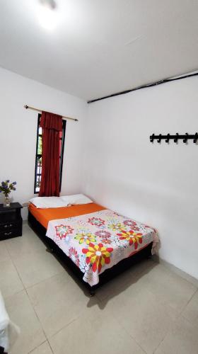 a bedroom with a bed in a room with a window at Finca la Campechana in Cumaral