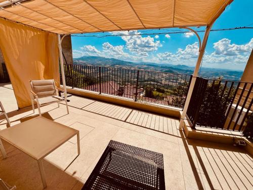 a balcony with a table and a chair and a view at Independent House a due passi dal Centro Storico in San Marino