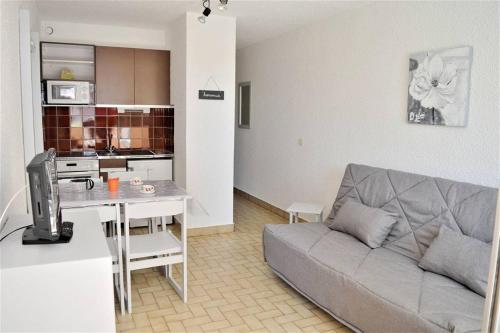 a living room with a couch and a table with a tv at Joli studio cabine à 500m plages in Cavalaire-sur-Mer