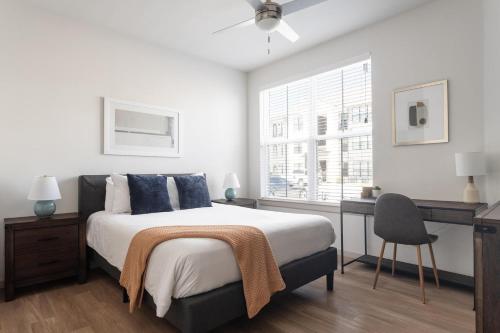 a bedroom with a bed and a desk and a window at Landing Apartments Austin - Pflugerville in Pflugerville