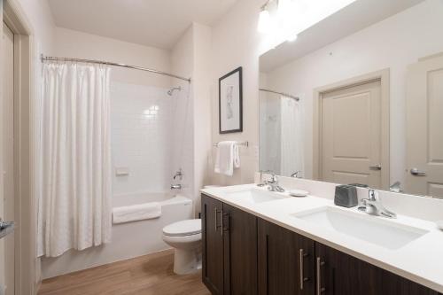 a white bathroom with a sink and a toilet at Landing Apartments Austin - Pflugerville in Pflugerville