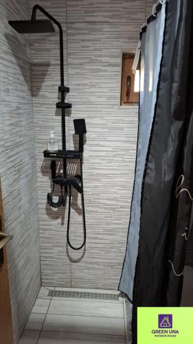 a shower with a black shower curtain in a bathroom at Green Una Wooden House in Kulen Vakuf