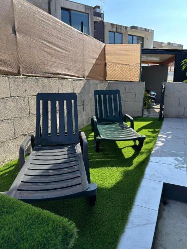 two blue chairs sitting on the grass in a yard at Casa de Ferias Tranquilo in Bitarães