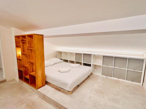 1 dormitorio con 1 cama con sábanas blancas y estanterías en Attic Nest Intimité - confort en coliving, en Cagnes-sur-Mer