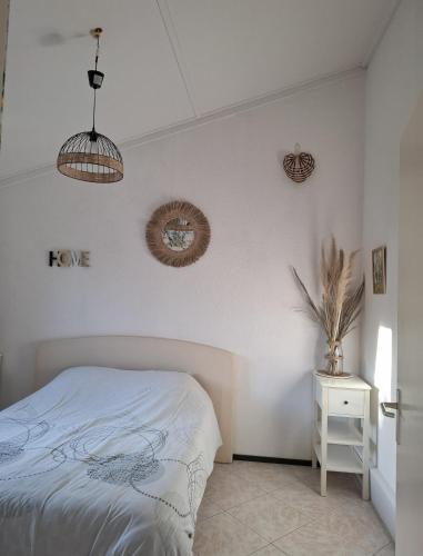 a bedroom with a bed and two wreaths on the wall at Villa Barbet in Lombez