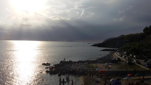 a group of people on a beach near the water at HOTEL MERCURIO SUL MARE - Fish restaurant and private beach in Capo Vaticano
