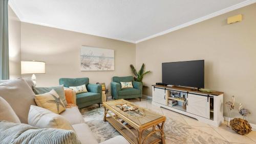 a living room with a couch and a flat screen tv at Coastal Clipper - Charming 2 BDR Walk to Beach in St. Augustine